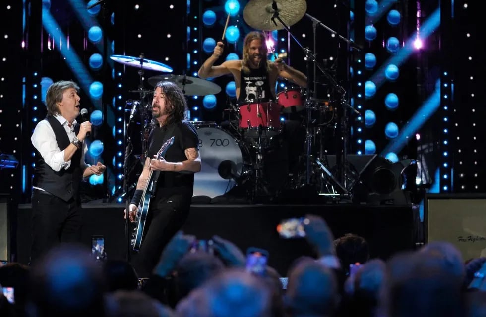 Paul McCartney, Dave Grohl y Taylor Hawkins, cuando el exBeatle introdujo a Foo Fighters en el Salón de la Fama del Rock & Roll. (https://fox8.com/)