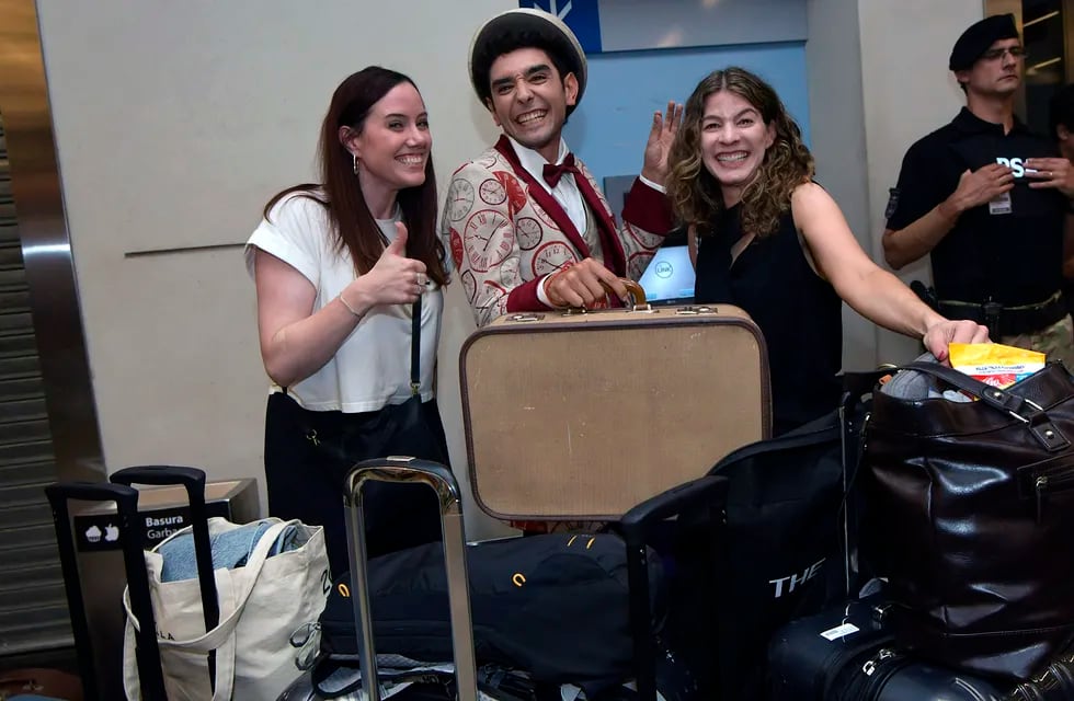 Bajo el cartel de arribos internacionales, un set de actores, ataviados como viajeros de otro tiempo, fueron parte de una peculiar recepción de bienvenida en el aeropuerto. / Foto:  Orlando Pelichotti