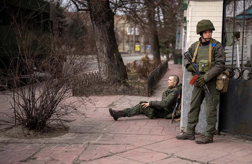 Un soldado ucraniano se sienta herido después de cruzar el fuego dentro de la ciudad de Kiev. AP