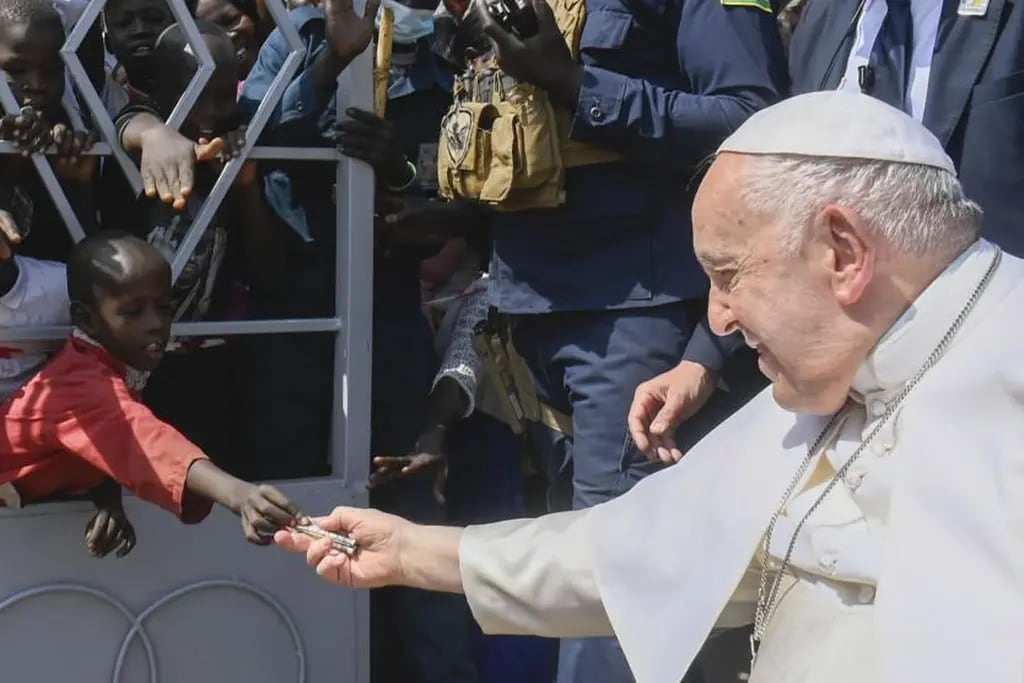 Papa Francisco recibe una limosna de un niño