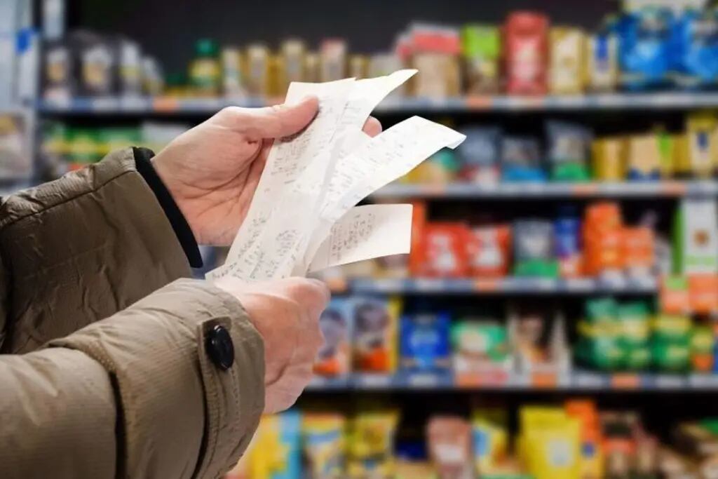 Persona leyendo recibo luego de comprar en el supermercado