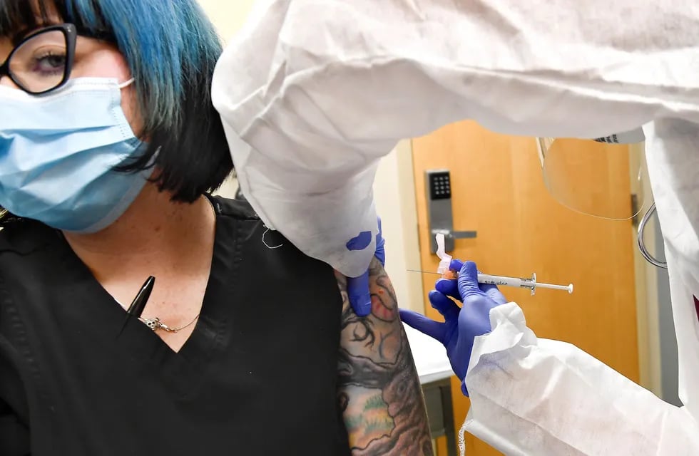 Una voluntaria es inyectada con la vacuna contra el coronavirus del laboratorio de Moderna.