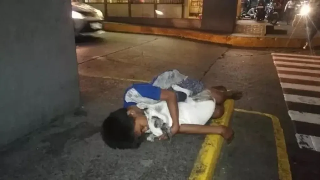 Un nene que duerme en la calle junto a su perro. Foto: Web
