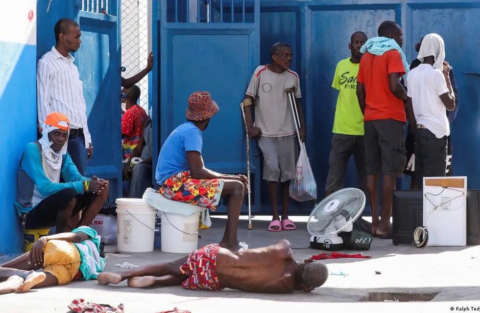 Los reclusos descansan en el suelo de la Penitenciaría Nacional tras violentos enfrentamientos en la capital que dañaron las comunicaciones y provocaron una fuga de esta prisión en Puerto Príncipe.