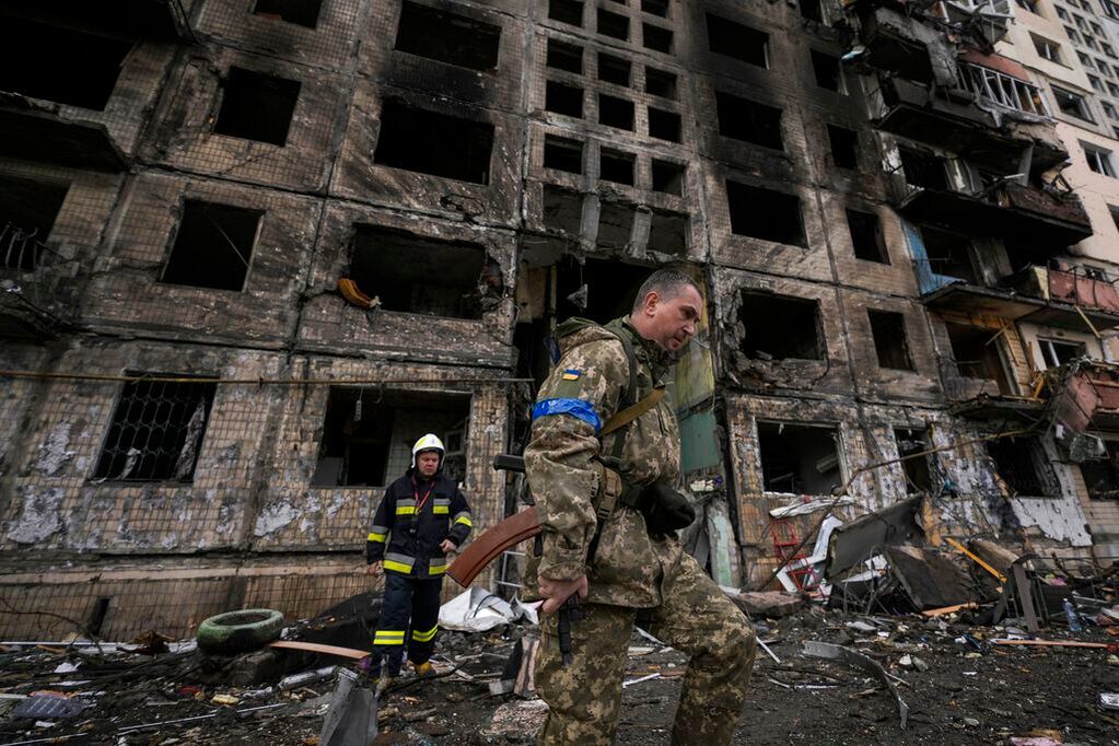 Soldados y bomberos ucranianos buscan sobrevivientes en un edificio derruido tras un ataque en Kiev. Foto: AP / Vadim Ghirda