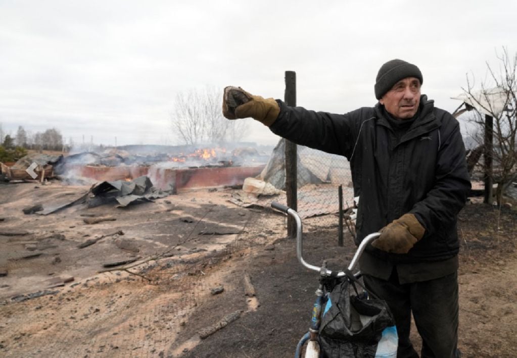 Un ciudadano local muestra los escombros de una casa privada después del bombardeo ruso en las afueras de Kiev, Ucrania (AP)