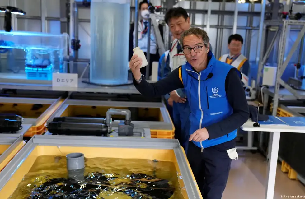 Rafael Mariano Grossi, director del Organismo Internacional de Energía Atómica (OIEA), muestra una botella vacía después de que alimentó platija en un tanque lleno de aguas residuales tratadas en un laboratorio, durante su visita a la dañada central nuclear de Fukushima el 05.07.2023.