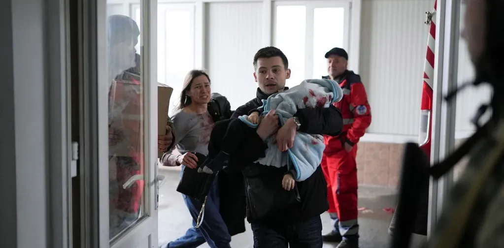 Marina y Fedor ingresan desesperados al hospital llevando a su pequeño hijo Kirill en Mariúpol / Foto: AP