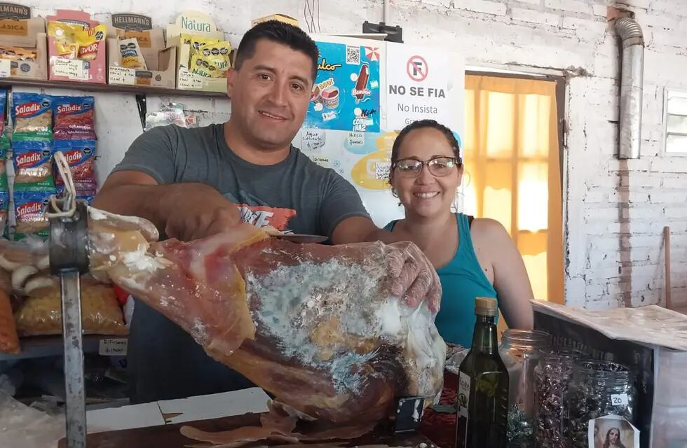 Alejandro y Natalia en su negocio, mostrando los jamones de San Rafael. | Foto: gentileza
