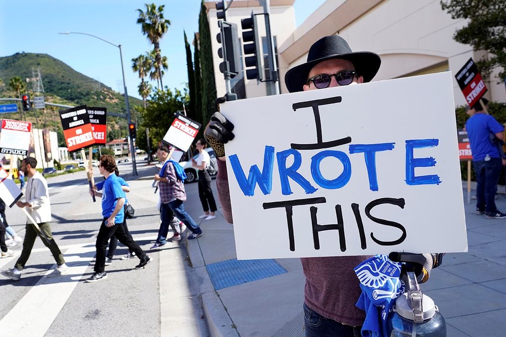 El juez Hardy, escritor de la serie de televisión "True Lies", sostiene un cartel mientras los miembros del piquete del Sindicato de Escritores de Estados Unidos frente a los estudios Warner Bros, en Burbank, California. (AP)