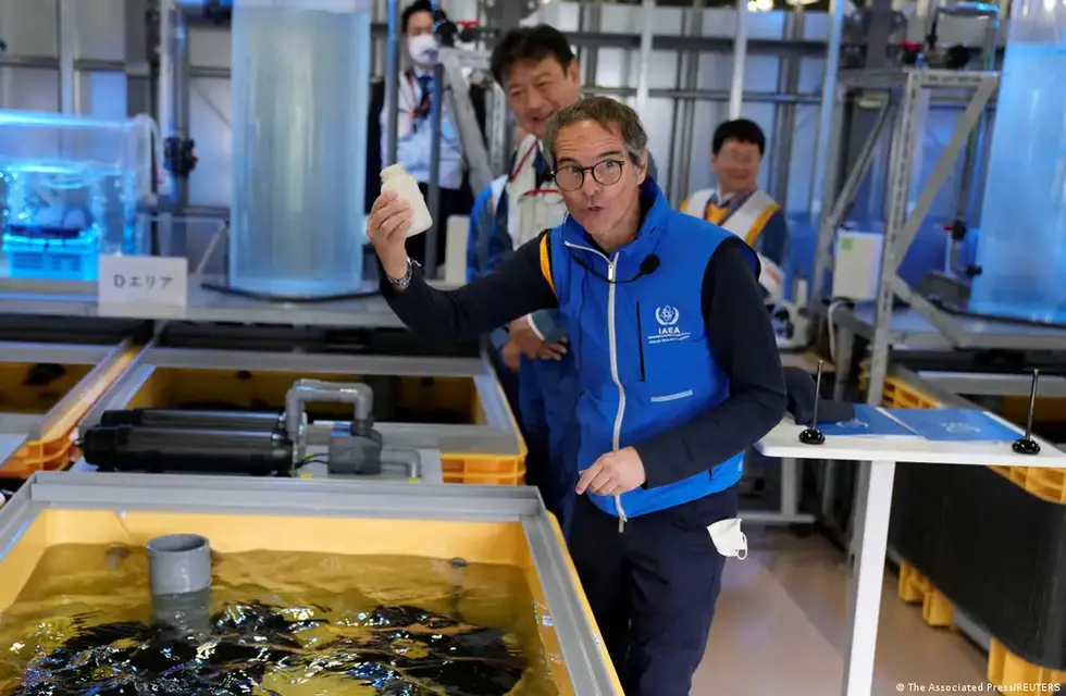 Rafael Mariano Grossi, director del Organismo Internacional de Energía Atómica (OIEA), muestra una botella vacía después de que alimentó platija en un tanque lleno de aguas residuales tratadas en un laboratorio, durante su visita a la dañada central nuclear de Fukushima el 05.07.2023.