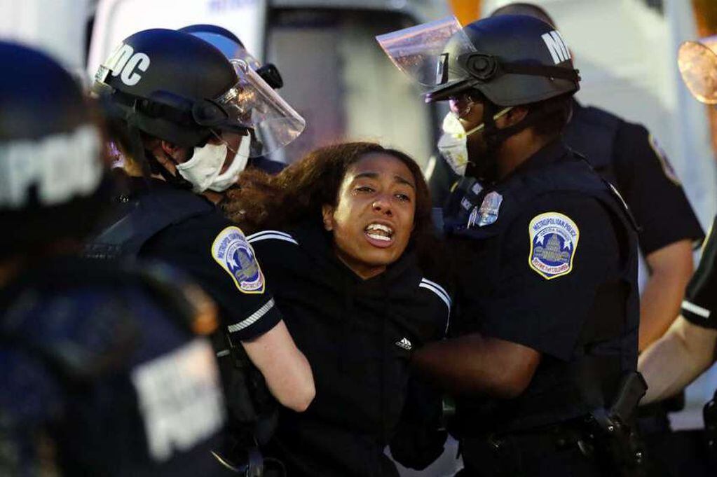 
AP | Con lágrimas en los ojos, un manifestante es detenido por la policía después de que un toque de queda entró en vigencia durante una protesta por la muerte de George Floyd.
   