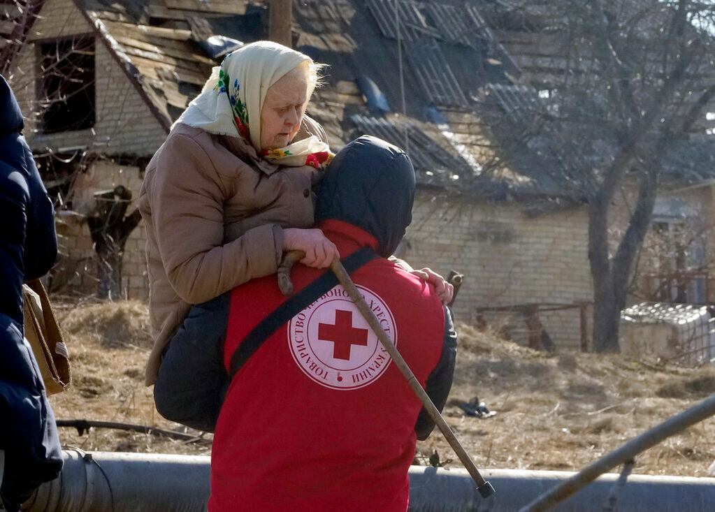 Un trabajador de la Cruz Roja traslada a una anciana durante la evacuación de Irpín. Foto: AP / Efrem Lukatsky