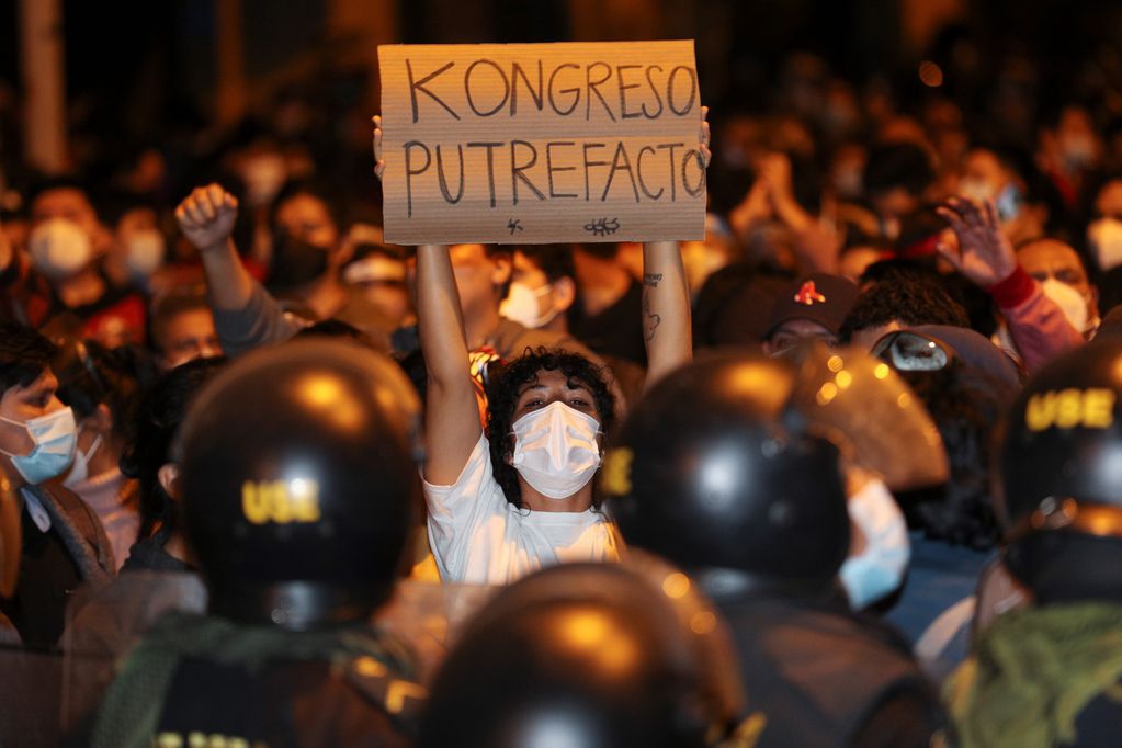 Un hombre sostiene un cartel que dice en español "Congreso podrido" durante una protesta contra la decisión del Congreso de derrocar al presidente Martín Vizcarra en Lima. 