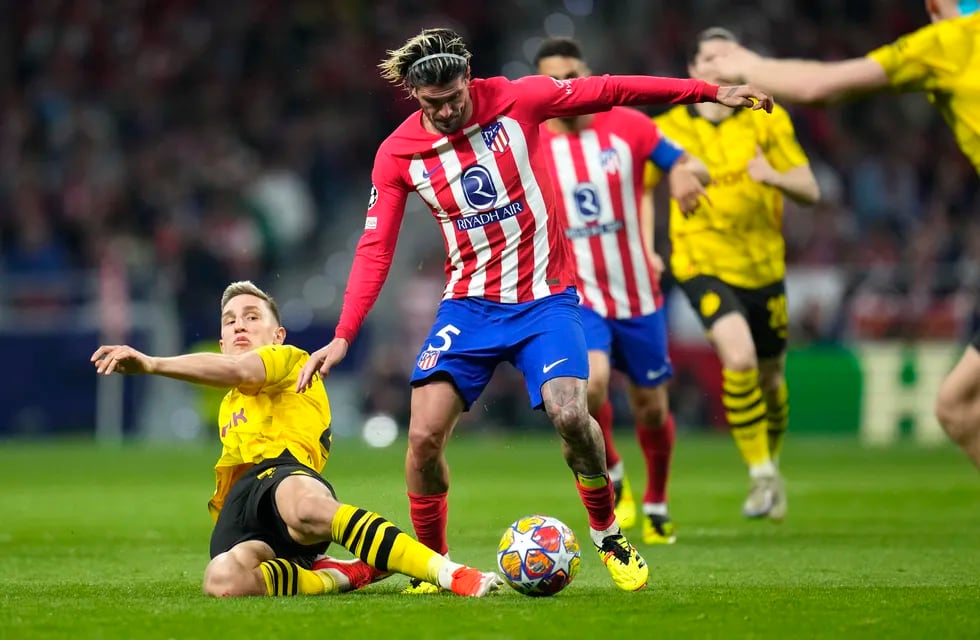 Rodrigo De Paul (centro) del Atlético del Madrid pugna por el balón con Nico Schlotterbeck del Borussia Dortmund en los cuartos de final de la Liga de Campeones, el miércoles 10 de abril de 2024, en Madrid.