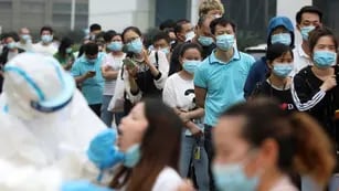 Testeos. Las personas hacen fila para las pruebas de coronavirus en una gran fábrica en Wuhan, en la provincia de Hubei, en el centro de China (AP/Archivo).