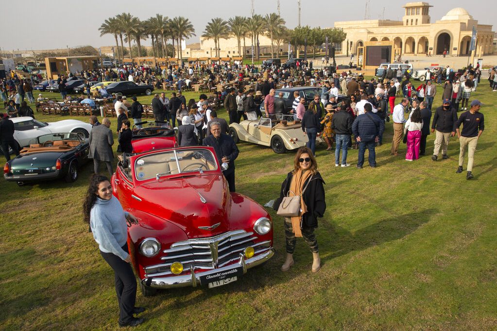 Entusiastas de los automóviles posan para la foto durante una muestra de coches clásicos el 19 de marzo de 2022, en El Cairo, Egipto. (AP Foto/Amr Nabil)