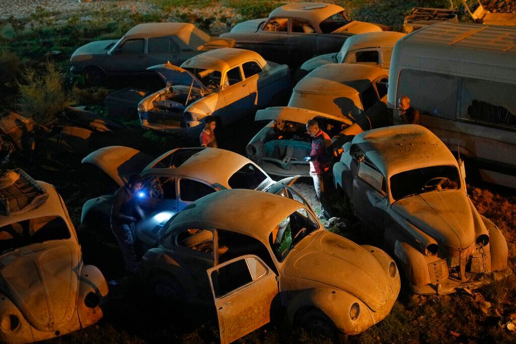 Mecánicos seleccionan vehículos para restaurarlos el viernes 8 de abril de 2022, en un lote en El Saff, en las afueras de El Cairo. Mohamed Wahdan, un empresario egipcio y coleccionista de vehículos clásicos, dice haber acumulado más de 250 automóviles vintage, antiguos y clásicos en los últimos 20 años. (AP Foto/Amr Nabil)