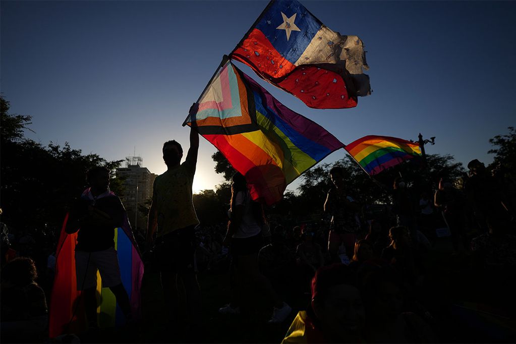 Miembros del Movimiento por la Integración y Liberación Homosexual celebran después de que los legisladores aprobaran una ley que legaliza el matrimonio y la adopción por parejas del mismo sexo, en Santiago, Chile, el martes 7 de diciembre de 2021. (AP Foto/Esteban Felix)