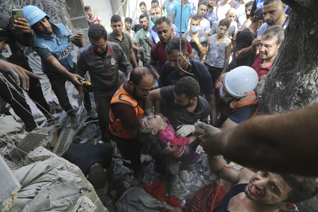 ARCHIVO - Palestinos rescatan a un niño de entre los escombros tras los ataques aéreos israelíes en Ciudad de Gaza, Franja de Gaza, miércoles 18 de octubre de 2023. (AP Foto/Abed Khaled)