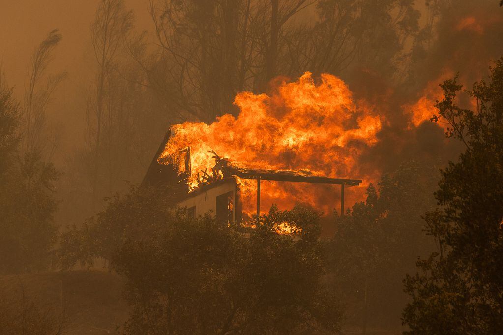 Las llamas consumen una casa la madrugada de hoy, cerca a la ciudad de Santa Juana (Chile). Foto: EFE