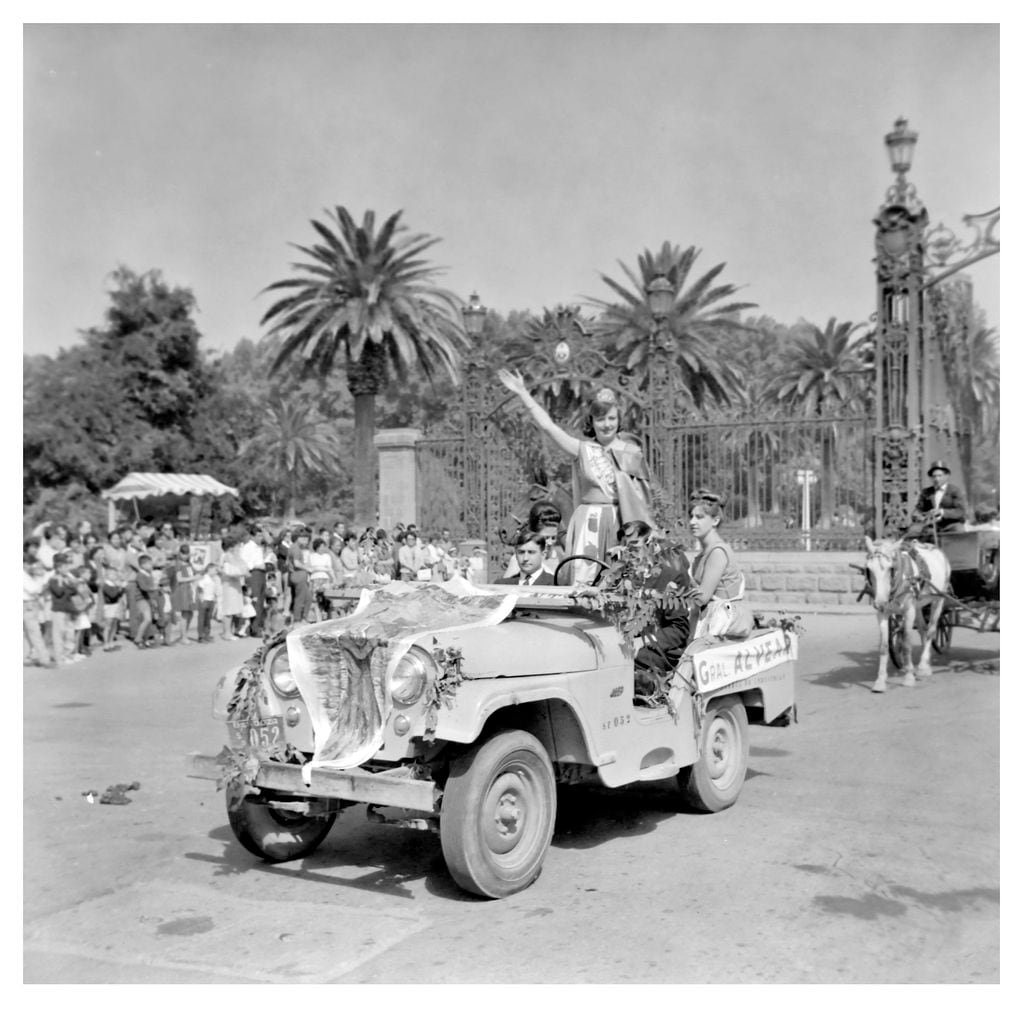 
El Jeep pasando debajo de los Portones del parque San martín, junto a la reina de General Alvear María Rosa Zasek, y parte de la corte. Foto: Archivo General de Mendoza. 