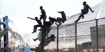 Migrantes saltando la Valla de Melilla, en España
