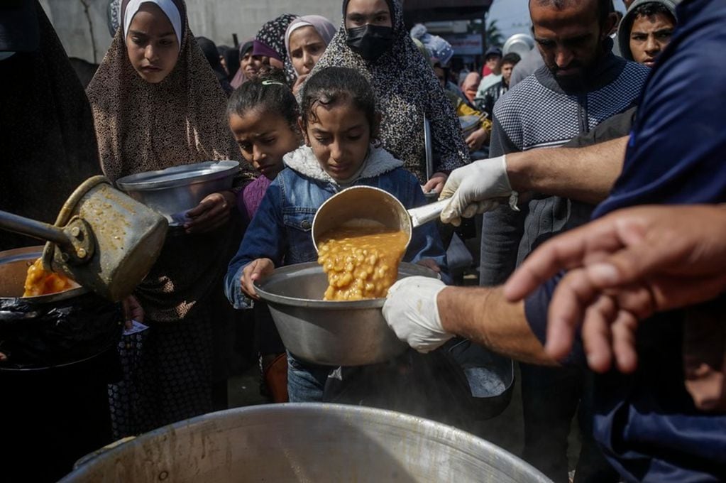 Niños palestinos desplazados reciben alimentos proporcionados por donantes árabes y palestinos, en una imagen de archivo. EFE/MOHAMMED SABER.