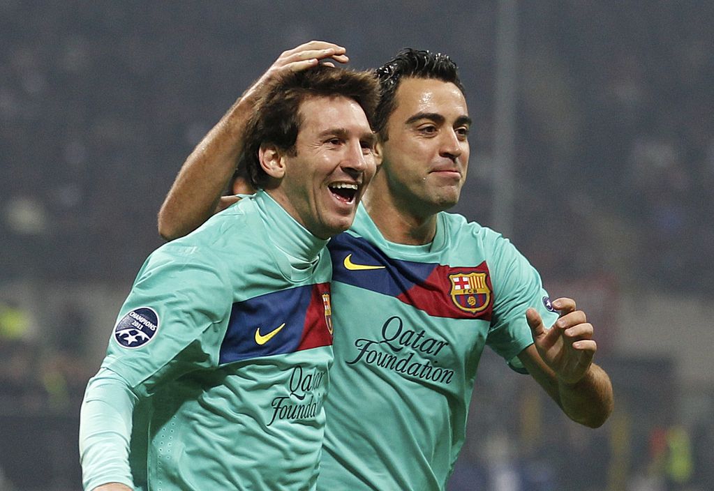 Lionel Messi con Xavi Hernández cuando compartían equipo en el mejor Barcelona. El ahora entrenador lo quiere de vuelta en el club. (AP / Archivo)
