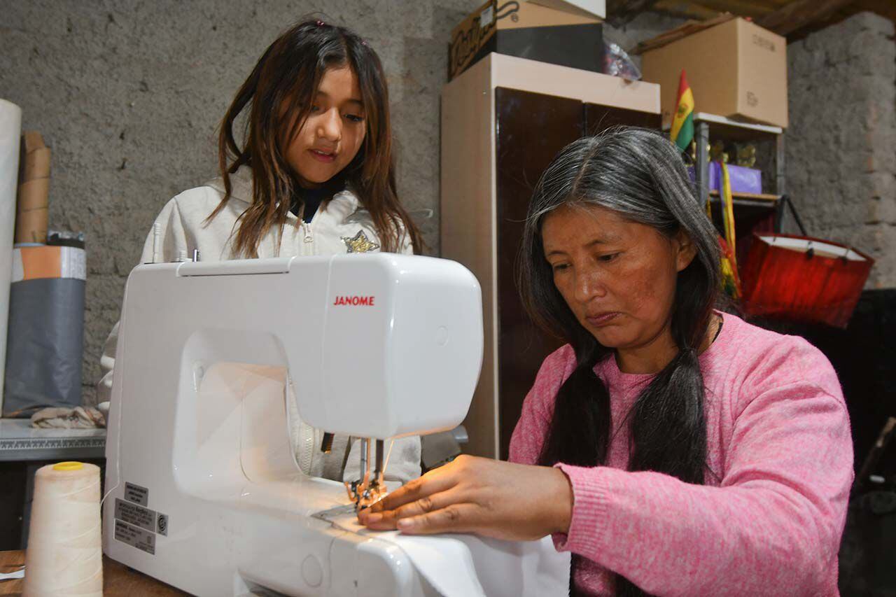 Katty enseña a su hija Mailén  a trabajar con las máquinas de coser  .
Foto: José Gutierrez / Los Andes 