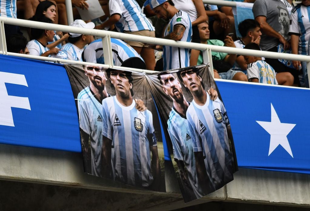 Lionel Messi y Diego Maradona, emblemas de la selección, en una bandera en el estadio de Santiago del estero, en el partido ante Curazao. (Twitter de ESPN)