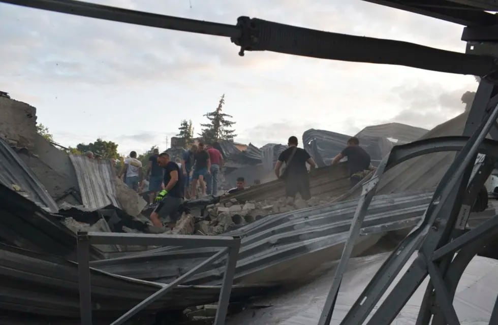 En esta imagen, distribuida por la Policía Nacional de Ucrania, varias personas retiran los escombros en el restaurante RIA Pizza, destruido por un ataque ruso en Kramatorsk, Ucrania, el 27 de junio de 2023.