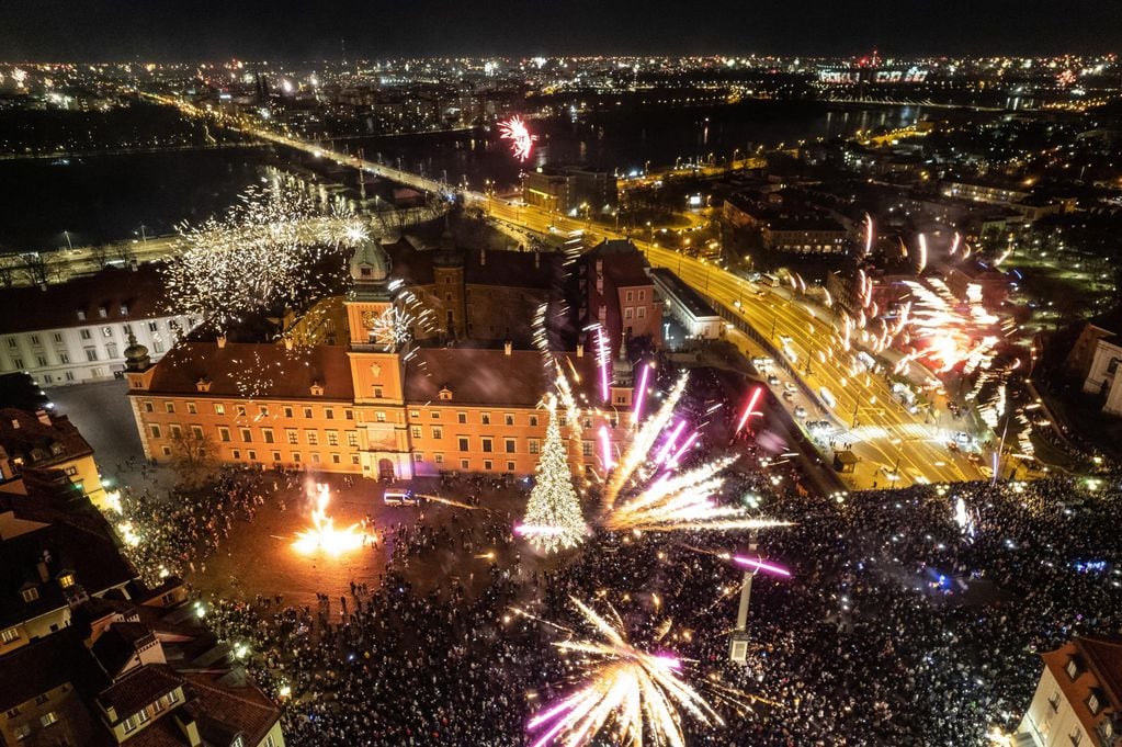 Residentes de la capital y turistas celebran la llegada del Año Nuevo en la plaza Zamkowy de Varsovia, Polonia, el 01 de enero de 2023. Foto: EFE/EPA/Rafal Guz POLAND OUT