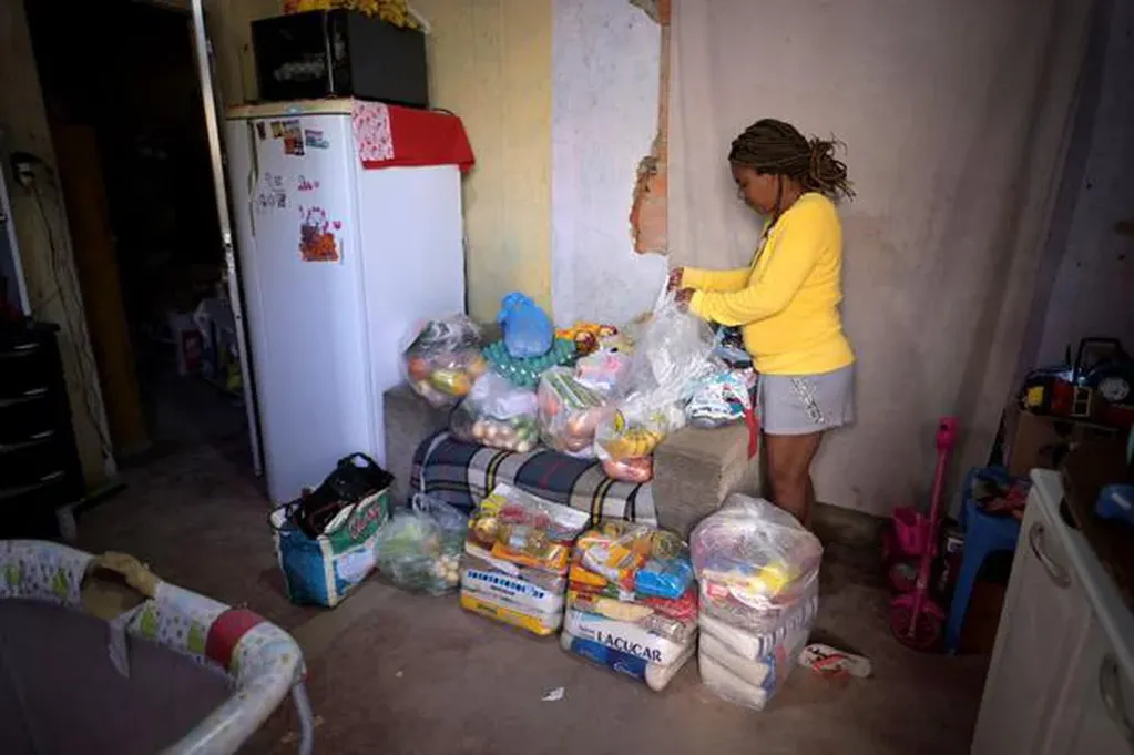 Celia, madre de Miguel Barros, de 11 años, junto a las donaciones de alimentos que recibió. Foto: Web