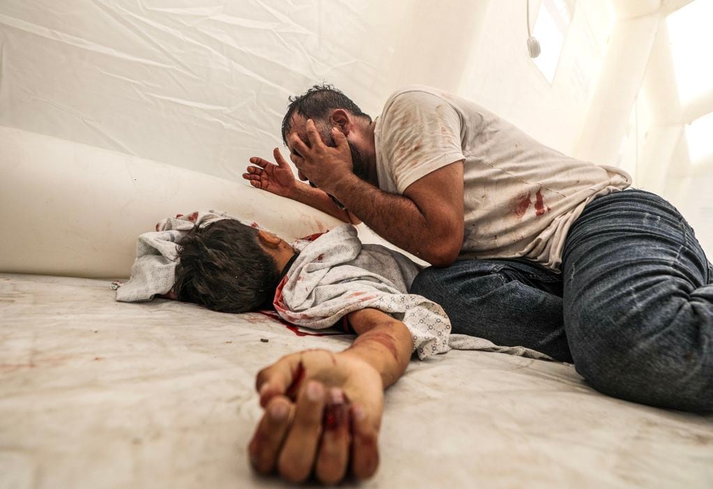 -FOTODELDÍA- EA1514. GAZA, 09/10/2023.- Un hombre llora junto al cadáver de su hijo en el hospital de Al-Shifa, tras un nuevo ataque aéreo sobre la ciudad de Gaza, este lunes. El Ejército israelí bombardeó intensamente durante la noche 500 objetivos de las milicias palestinas en Gaza, mientras continúan los combates dentro de Israel en al menos siete puntos donde todavía hay milicianos de Hamás.EFE/ Mohammed Saber
