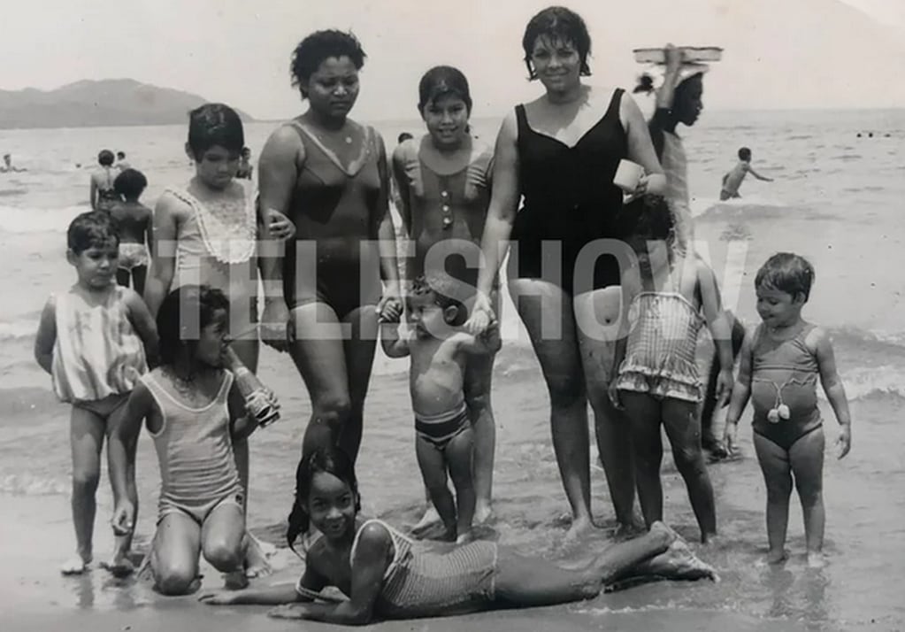 Catherine Fulop en la playa, con su mamá y sus hermanas