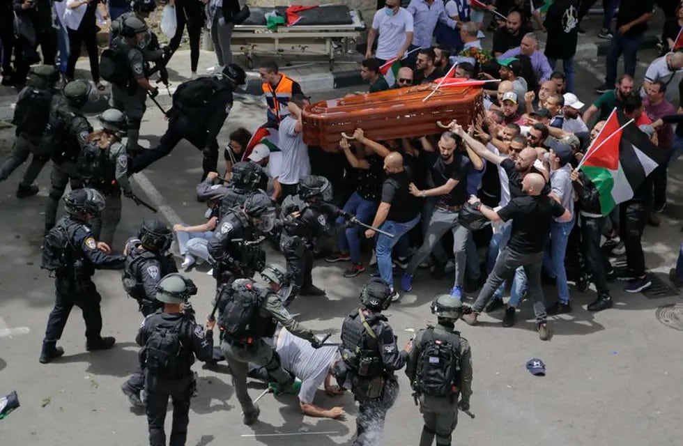 Los agentes israelíes se enfrentan a los asistentes al funeral de Shireen Abu Akleh a la salida del hospital, en Jerusalén. / Foto: AP