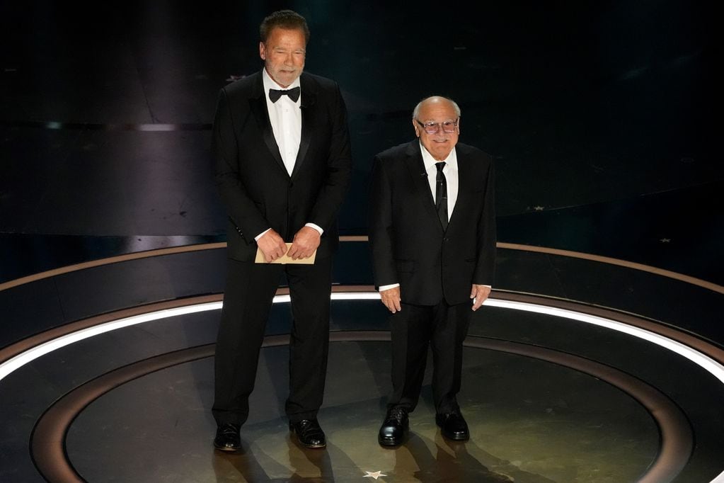 Arnold Schwarzenegger, izquierda, y Danny DeVito entregan el premio a los mejores efectos visuales durante los Oscar el domingo 10 de marzo de 2024 en el Dolby Theatre de Los Ángeles. (Foto AP/Chris Pizzello)