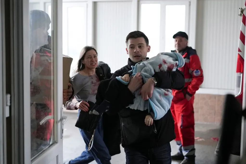 Marina y Fedor ingresas desesperados al hospital llevando a su pequeño hijo Kirill. / Foto: AP