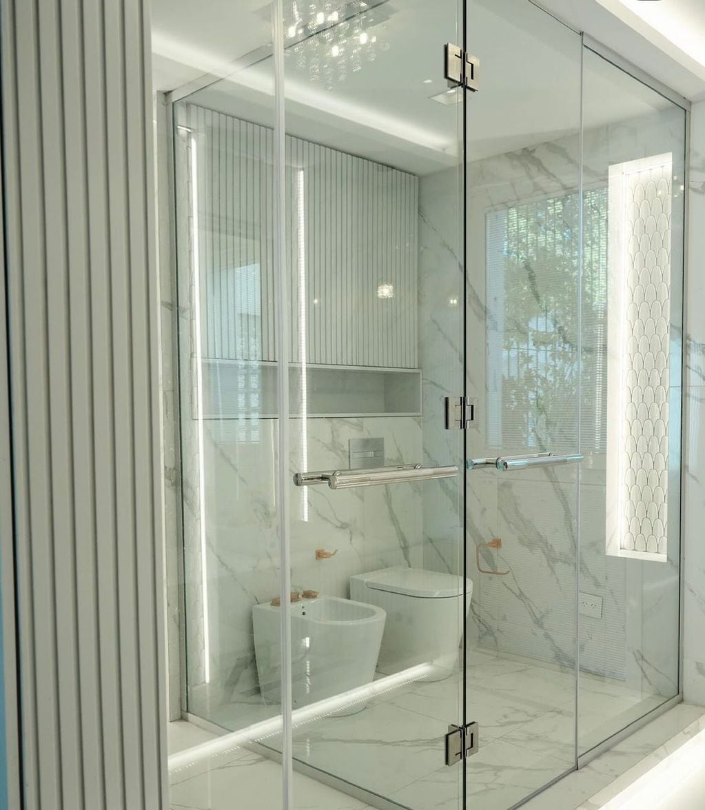 El espacio de inodoro y bidet está separado de la ducha por una pared vidriada que genera, junto con las puertas, un box para cada espacio.