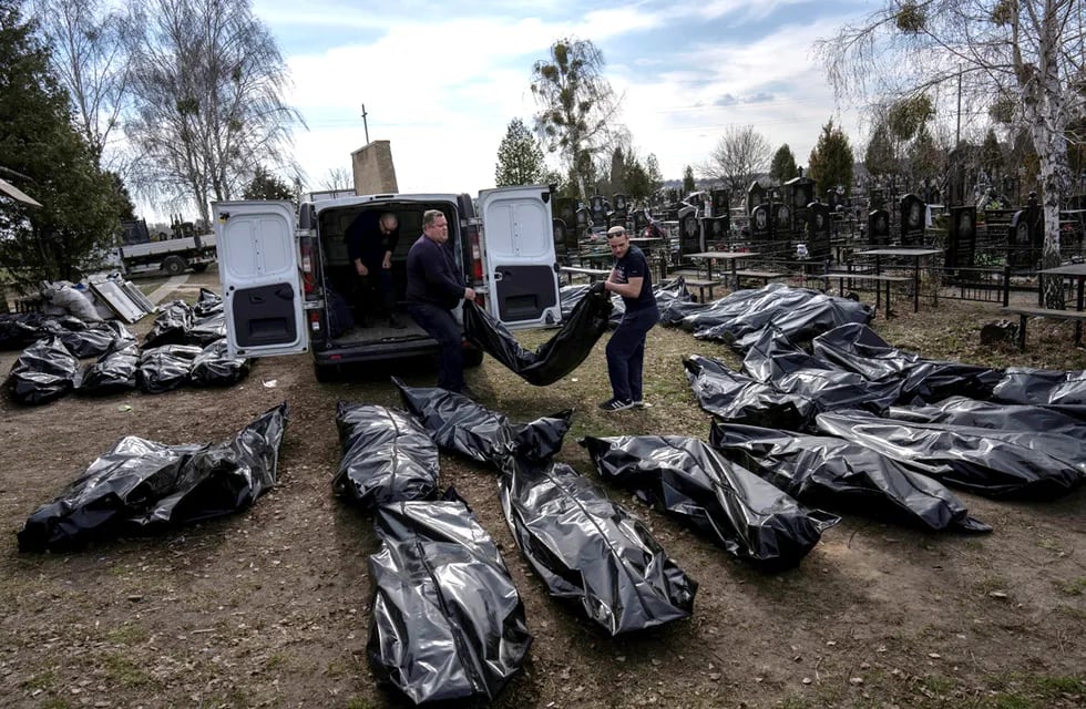 Trabajadores del cementerio descargan los cuerpos de los civiles asesinados desde una camioneta en el cementerio de Bucha, en las afueras de Kiev. (AP /Rodrigo Abd)