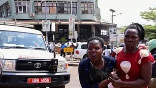 A woman reacts near the scene of a blast in Kampala