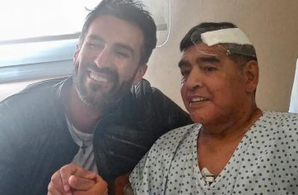 Diego Maradona junto a su médico personal, Leopoldo Luque antes de abandonar la clínica luego de una operación. / Gentileza.