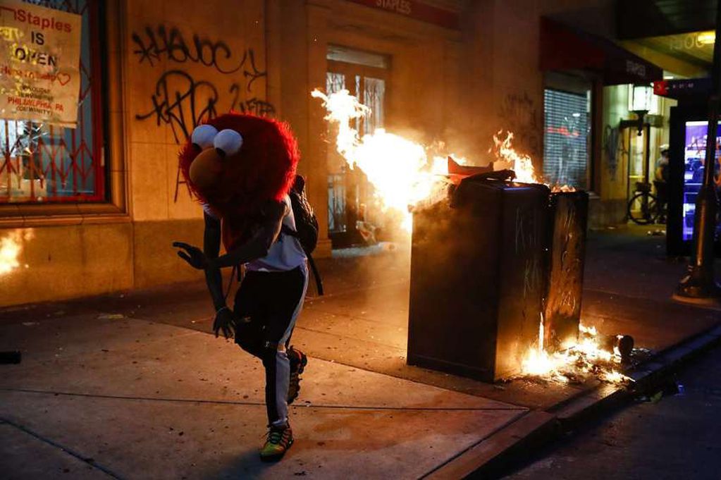 
AP | Un manifestante con una máscara de Elmo corre durante los disturbios en Filadelfia.
   