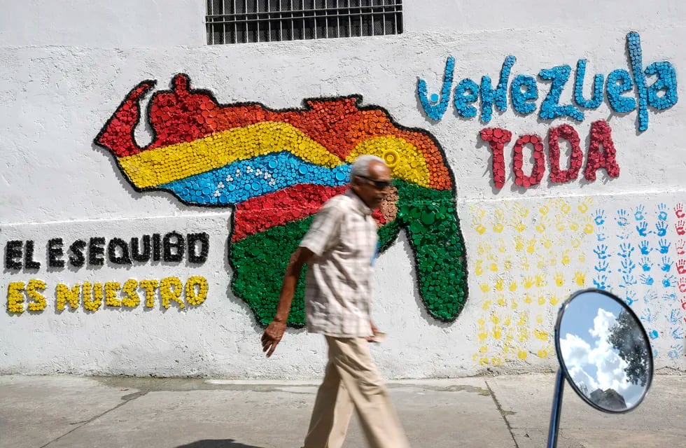 Un hombre camina frente a un mural de un mapa de Venezuela con el territorio de Esequibo incluido, en Caracas, el miércoles 29 de noviembre de 2023. (AP Foto/Matias Delacroix)