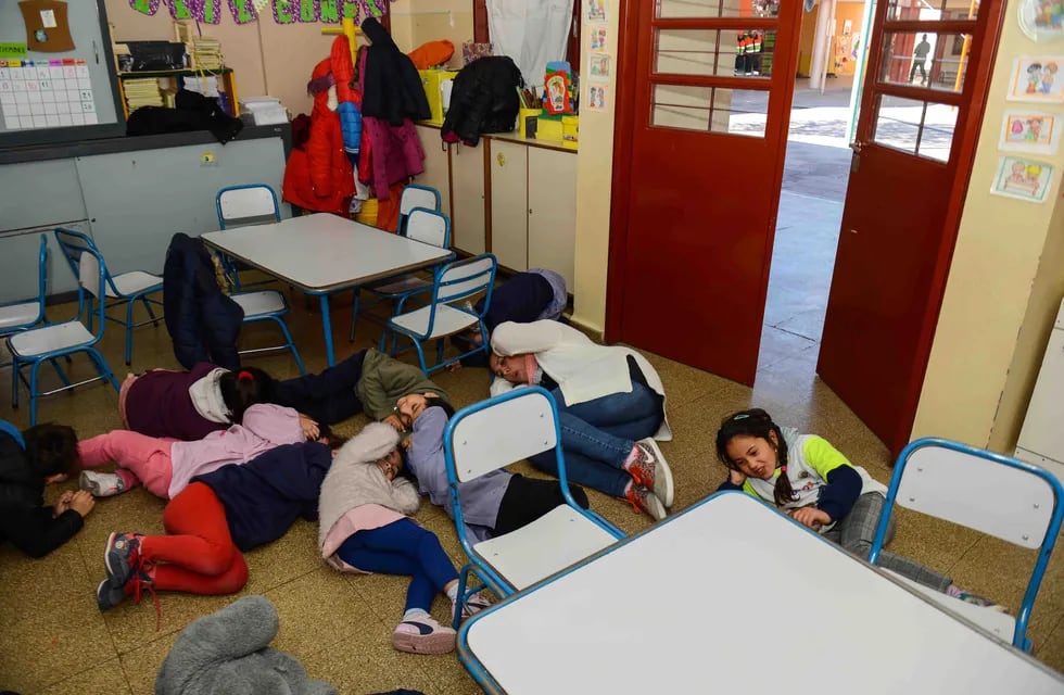 Simulacro. Niños durante un ejercicio sísmico en una escuela. Se cubren la cabeza y permanecen tirados en el suelo.