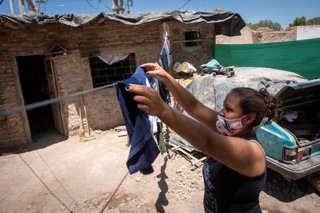Janet Moreno (32) tiende la ropa en el patio de su "nueva casa". Aunque hace varios años vive en el predio, hace unos días debió trasladarse a otro de los sectores luego de que se la forzara a reubicarse.