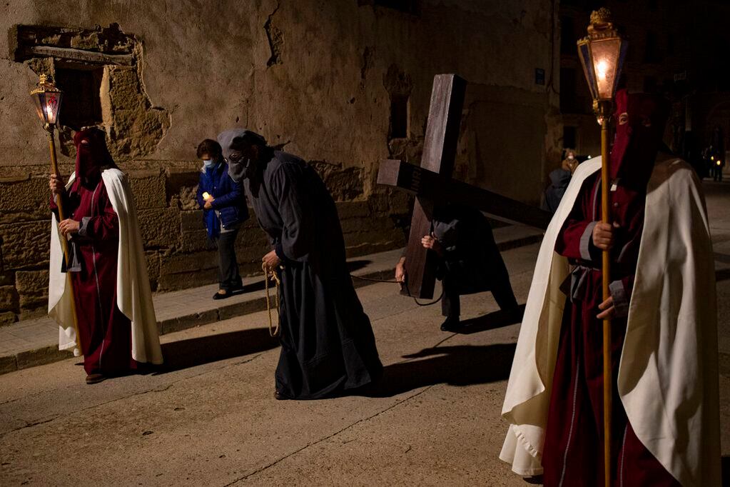 Penitentes participan en una procesión de Santa Santa conocida como "El Ensogado", en Siétamo, en el norte de España, el 14 de abril de 2022. (AP Foto/Álvaro Barrientos)