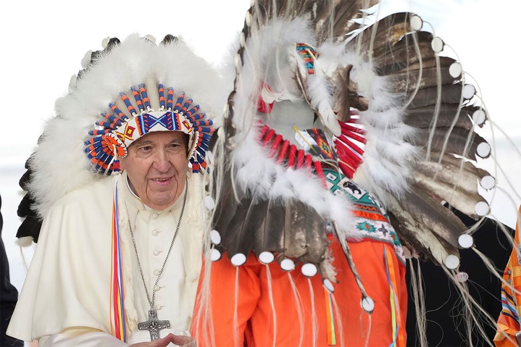 El Papa Francisco, a la izquierda, usa un tocado tradicional que le dieron después de disculparse con los indígenas durante una ceremonia en Maskwacis, Alberta. (Nathan Denette/The Canadian Press vía AP)