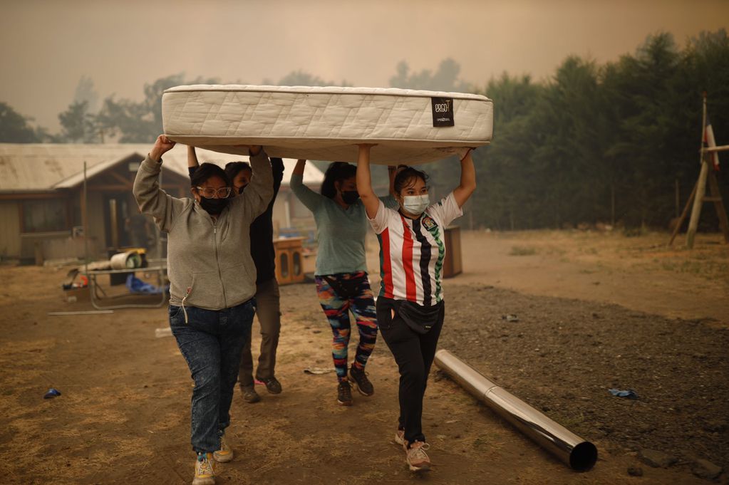 Habitantes recogen pertenencias durante un incendio en Santa Juana (Chile). Foto:  EFE